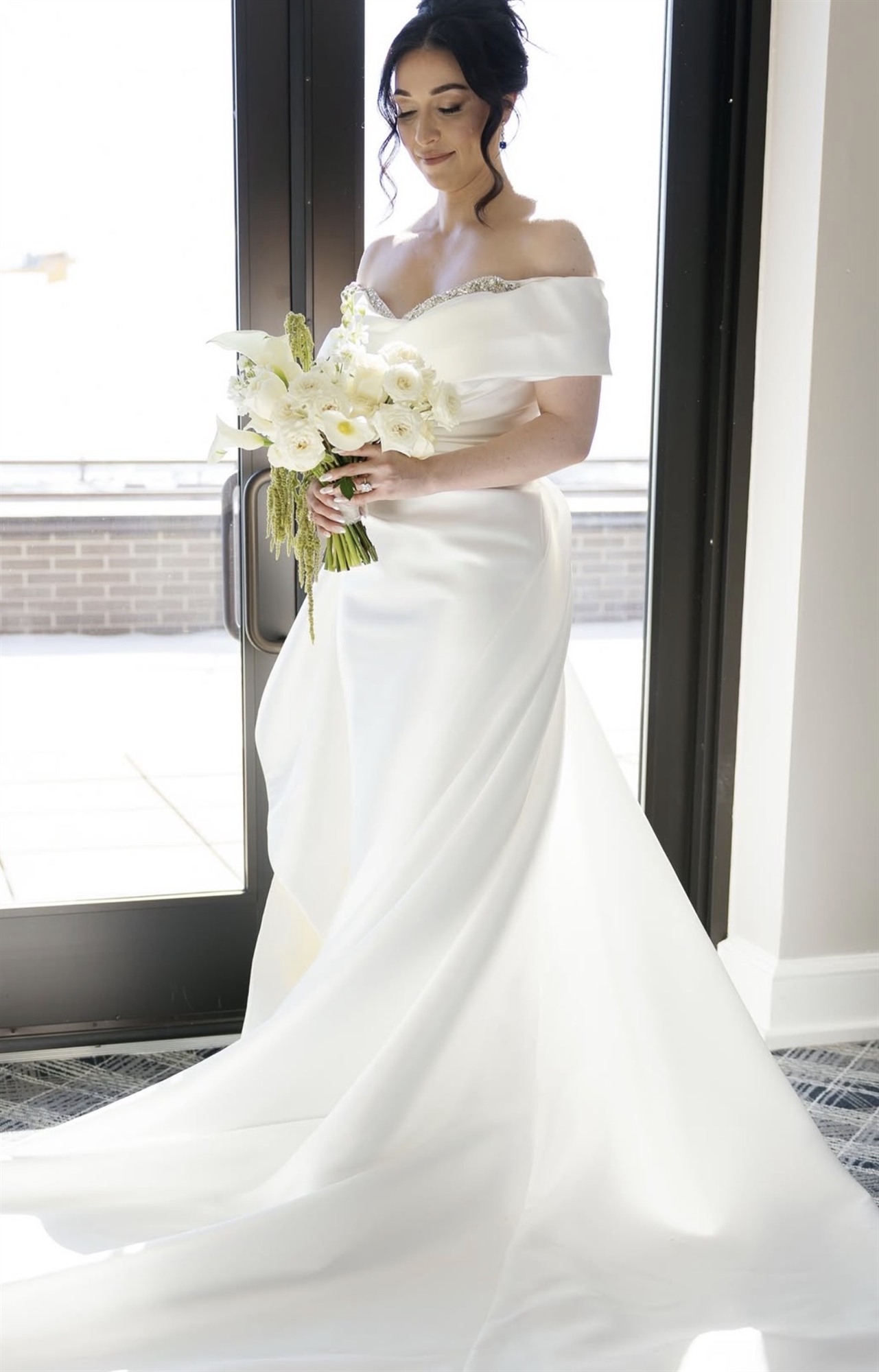 Bride in a doorway holding her bouquet