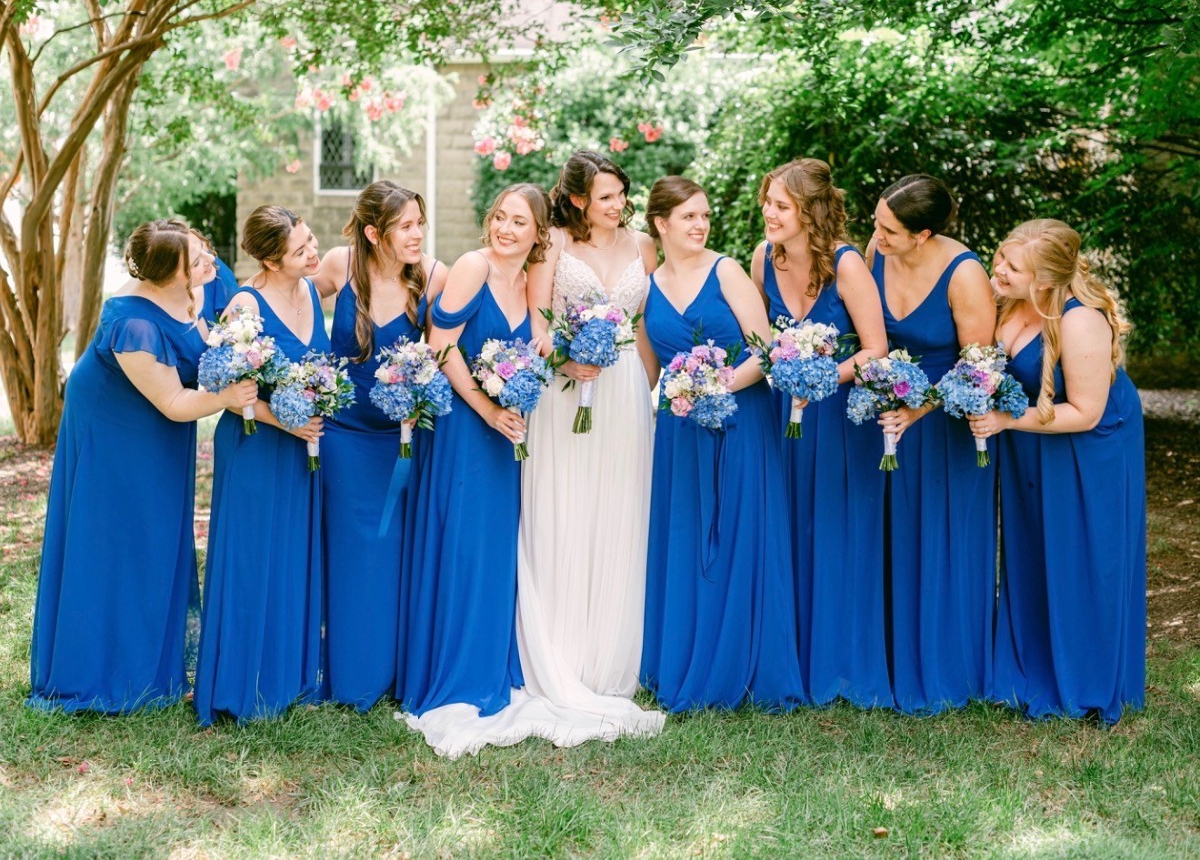Bride with her bridal party in blue gowns, garden setting
