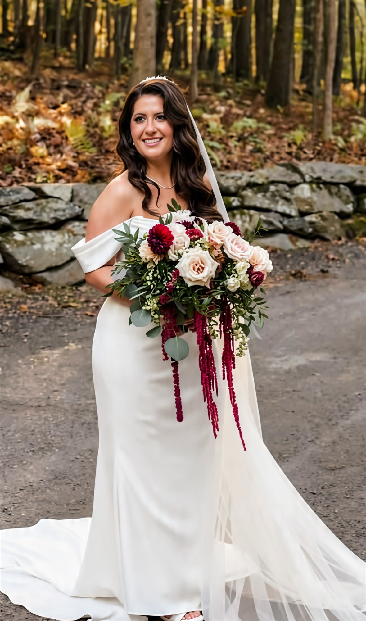 Bride in an off-shoulder gown by a stone wall, burgundy bouquet