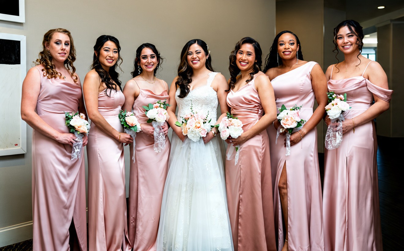 Bride with her bridal party in dusty-pink gowns, indoors