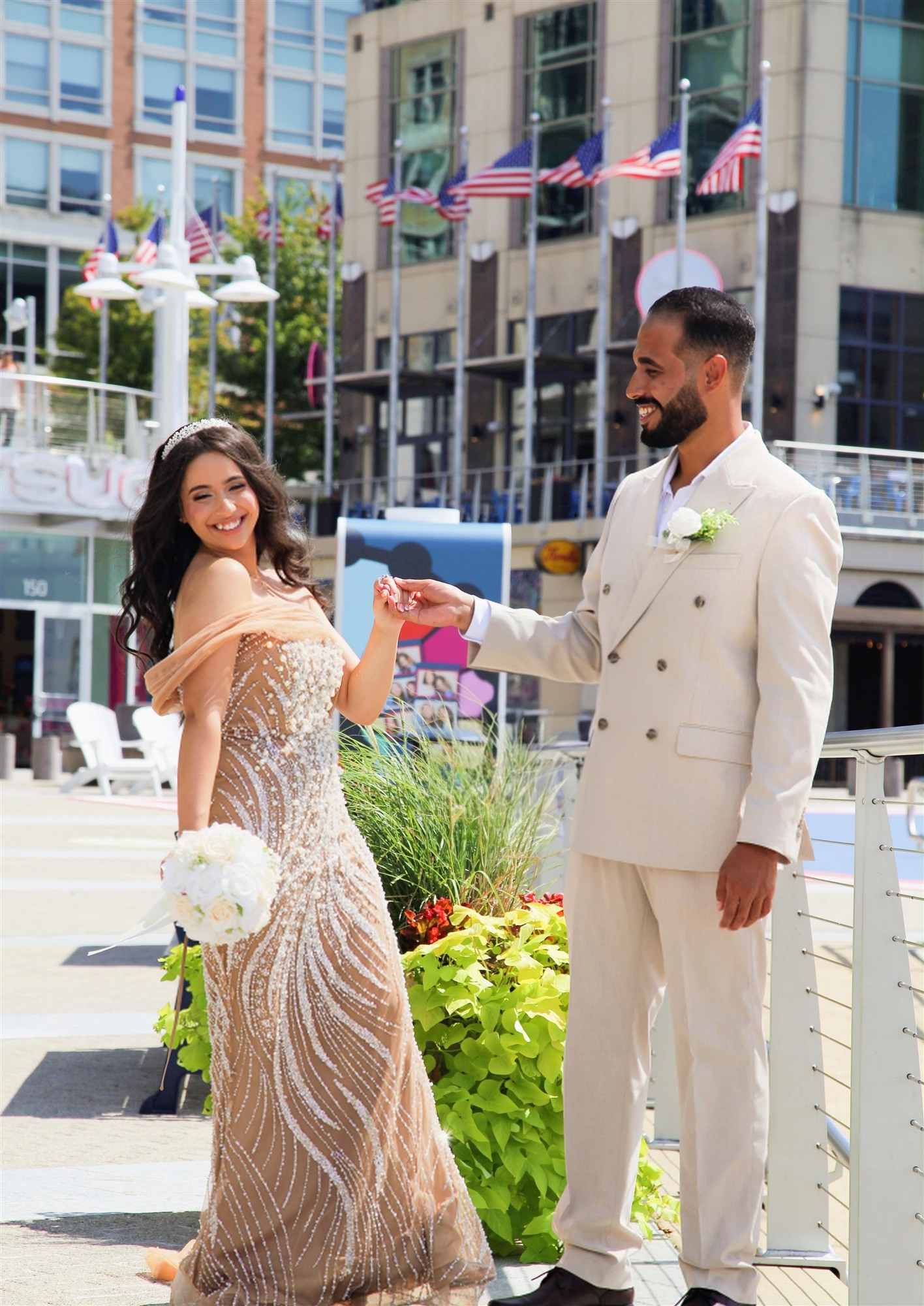 Bride and groom dancing together in a sunlit plaza