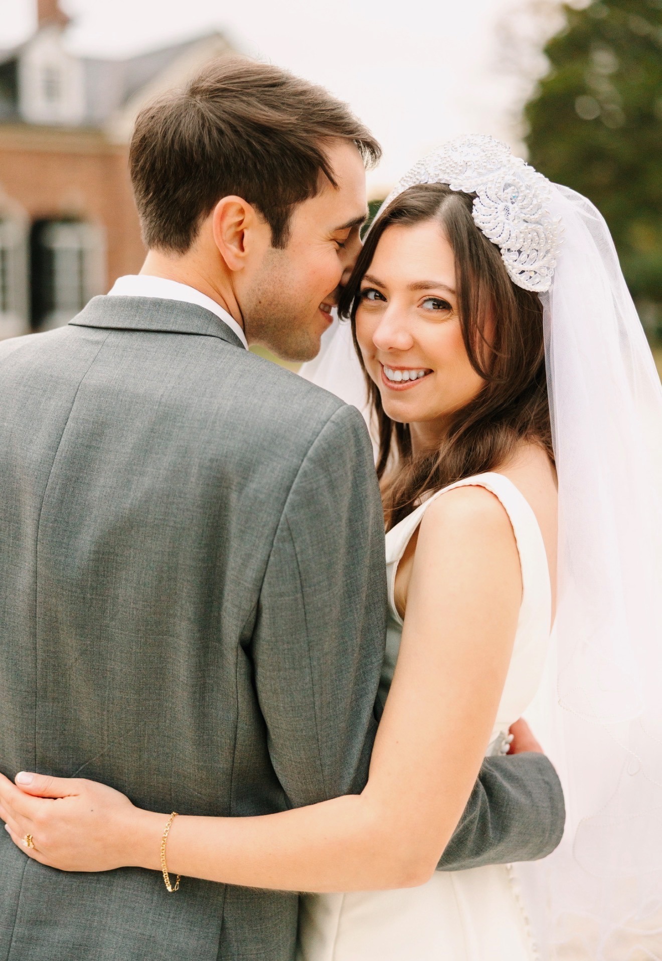 Bride and groom close together, bride glancing at camera, beaded headpiece