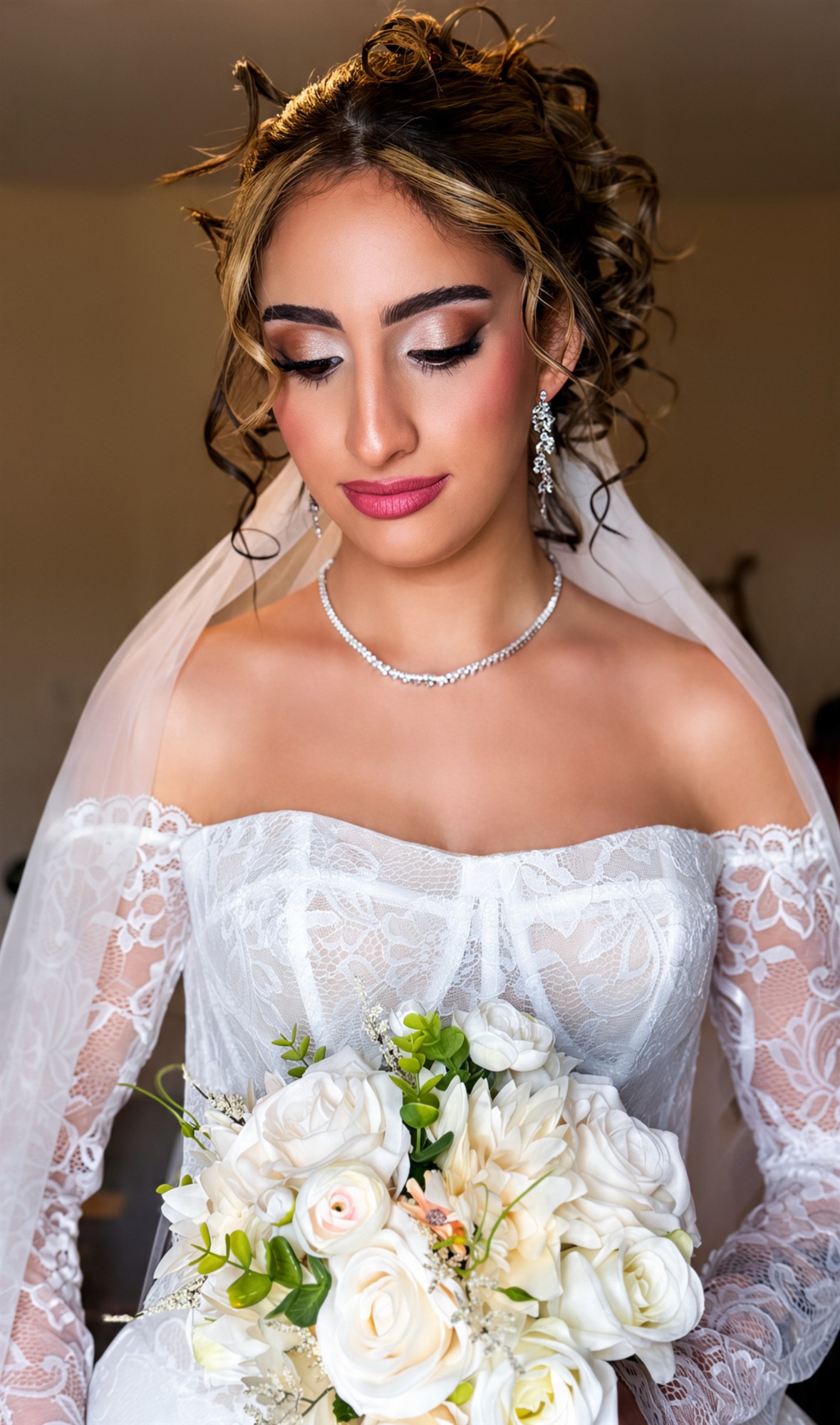 Close-up of finished bridal makeup, off-shoulder gown detail