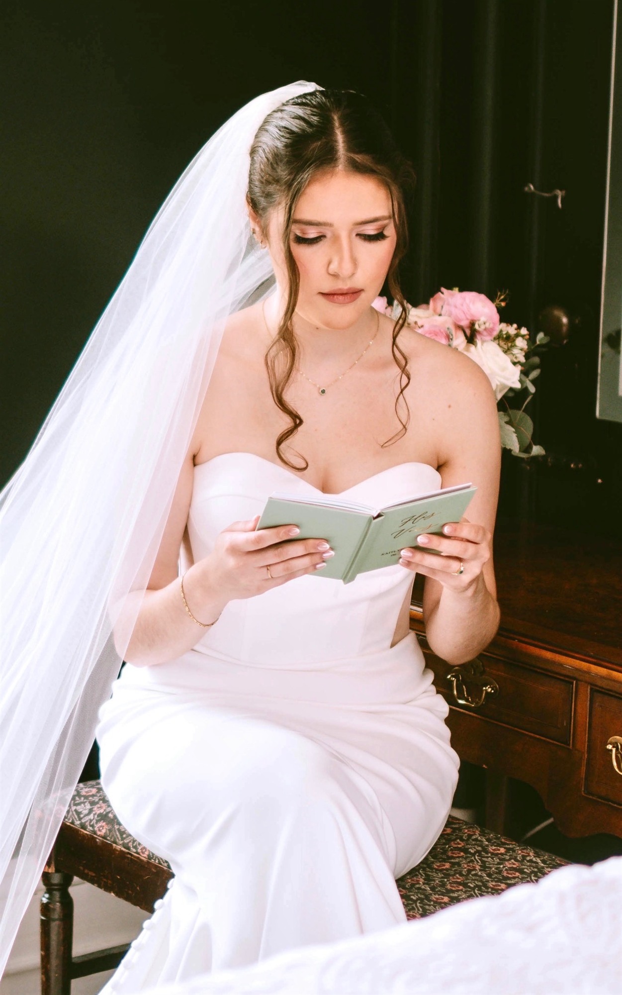 Bride reading her vows, seated with her bouquet