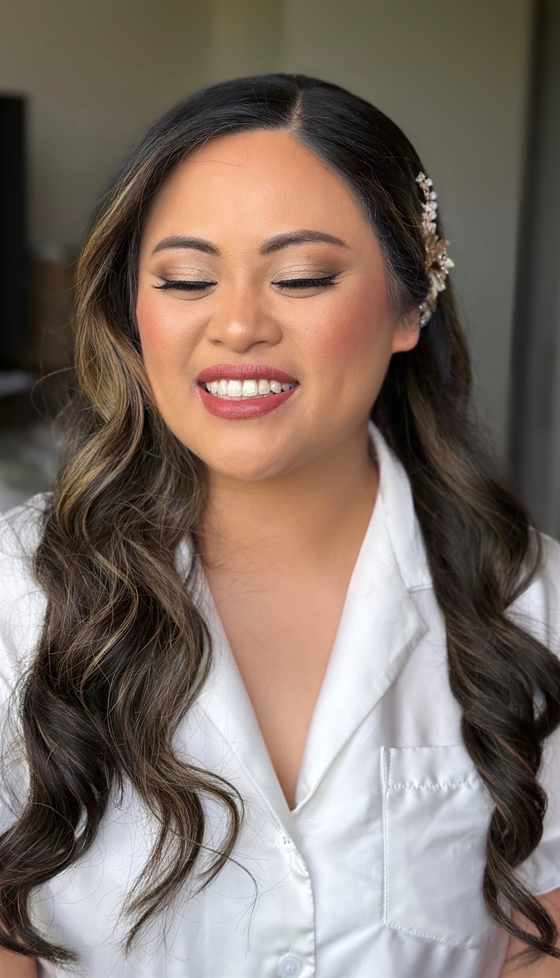 Close-up of finished bridal makeup, soft smile, bridal updo