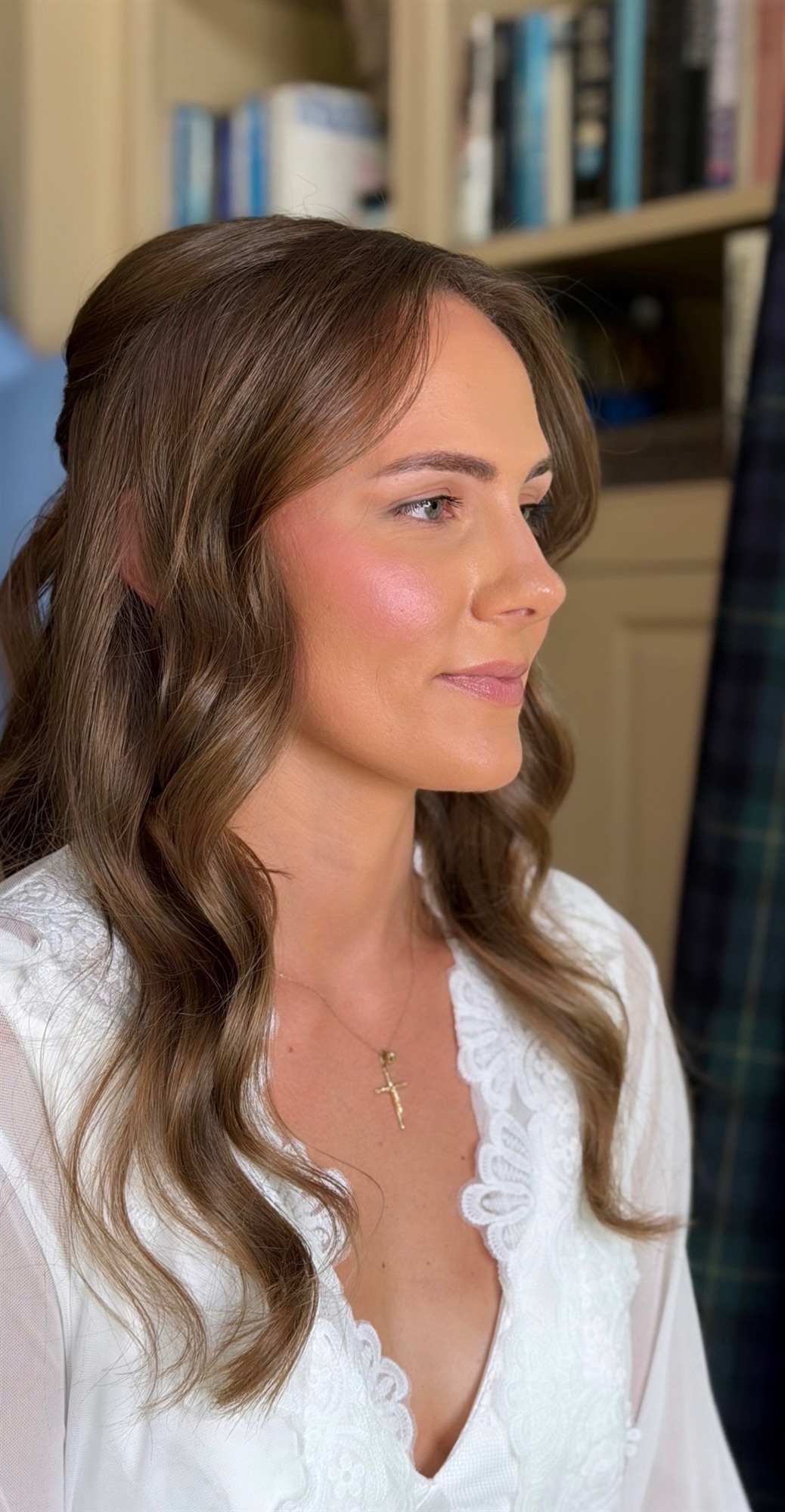 Profile close-up of finished bridal makeup, bookshelf backdrop