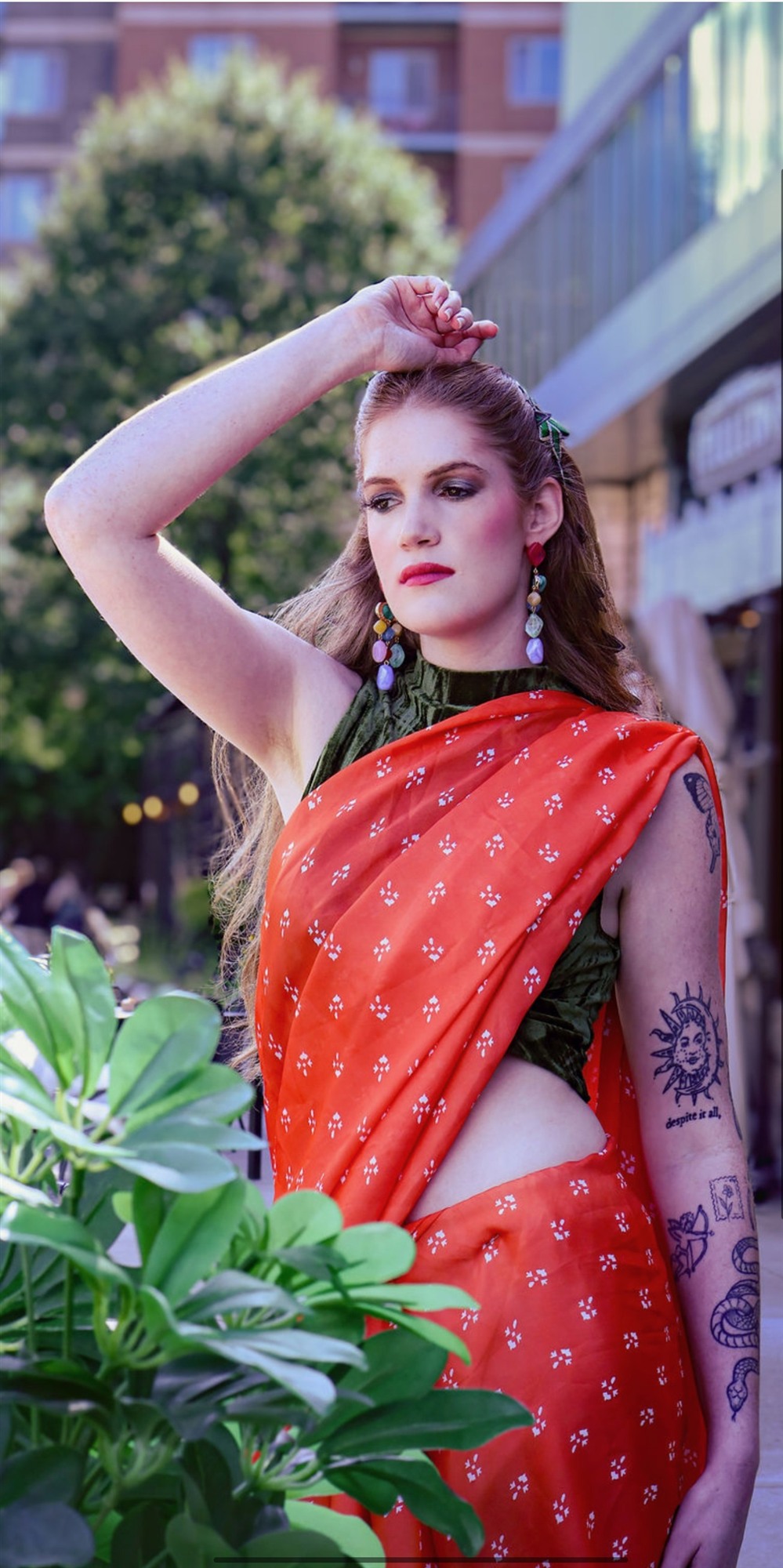 Editorial portrait in a red printed saree with a green blouse, city plaza