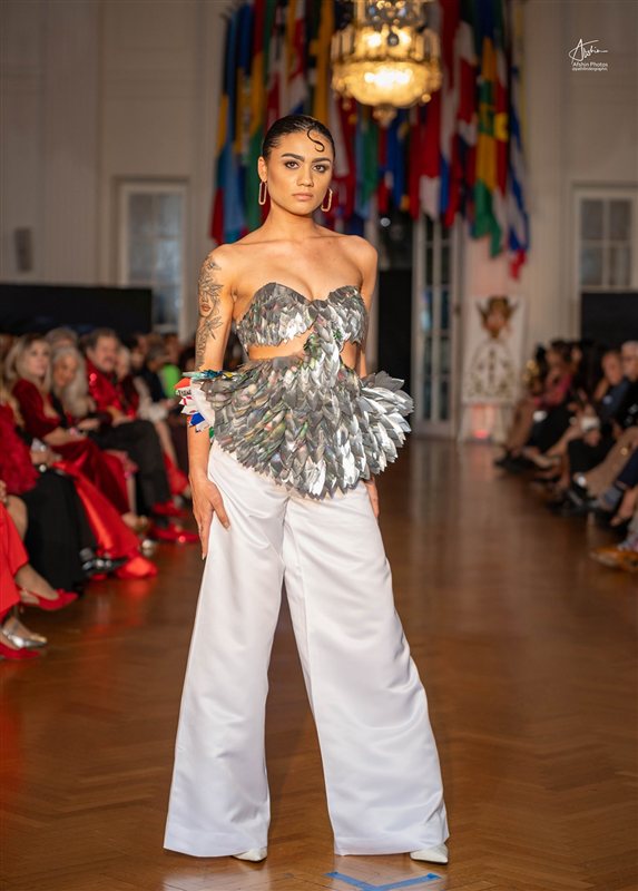 Model on the runway in a silver beaded top and trousers